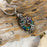 The Iridescent Cut Glass with Tree of Life Cremation pendant has the roots embracing a cut glass ring with shades of blue and green.
