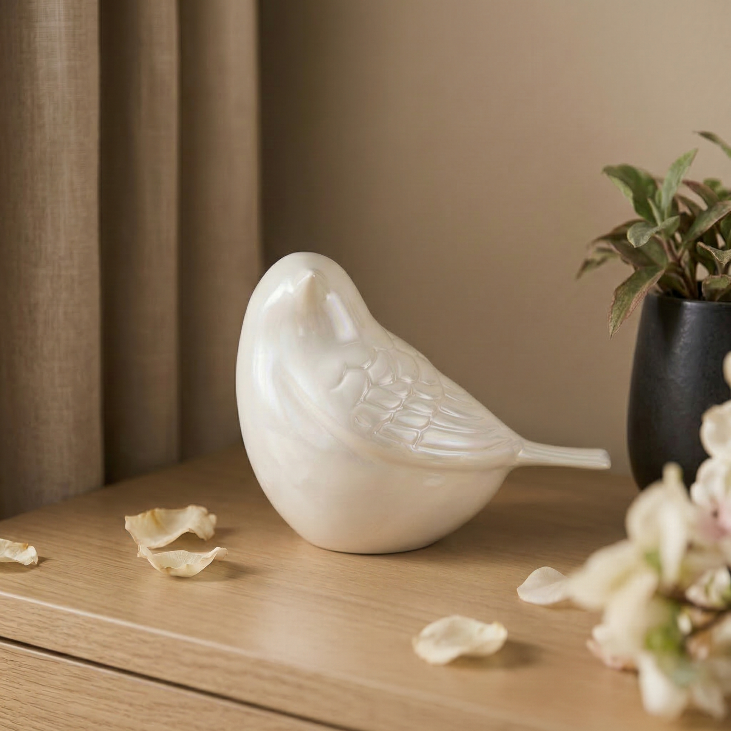 Elegant solid brass cremation urn in pearl white with gold trim and engraved band, displayed on a wooden surface in a warm memorial setting.
